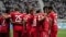  FC Bayern München-spelare på en fotbollsplan kramar om varandra.