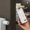 Bilden visar en ViCare-termostat på en radiator och ViCare-appen öppen på en smartphone